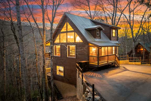 Modern mountain cabin with big windows, sunset views, and porch charm