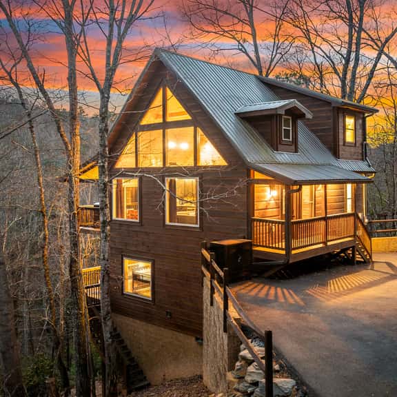 Modern mountain cabin with big windows, sunset views, and porch charm
